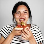 Girl with braces eating pizza