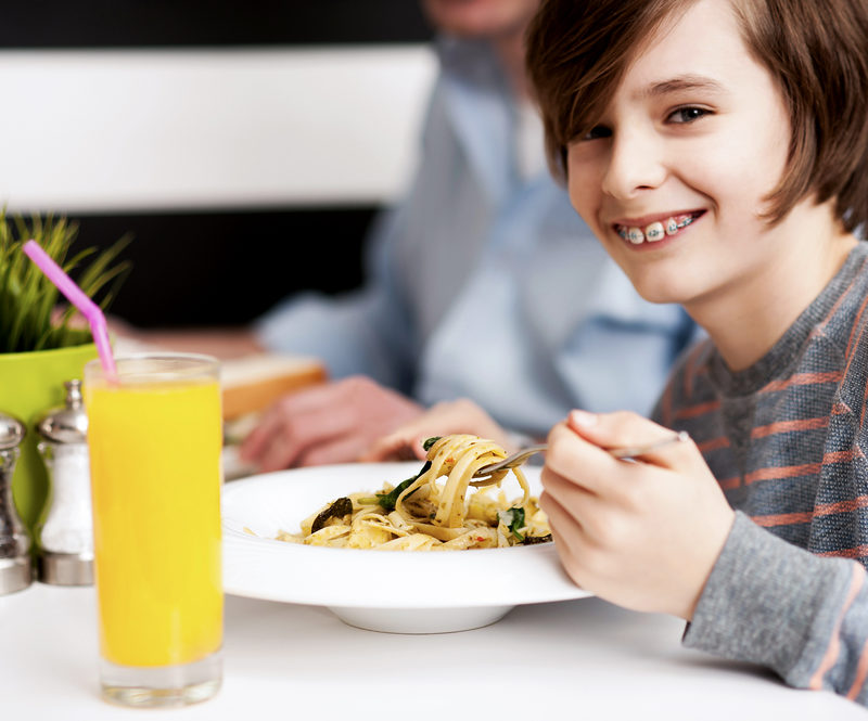 boy wearing braces in a restaurant table