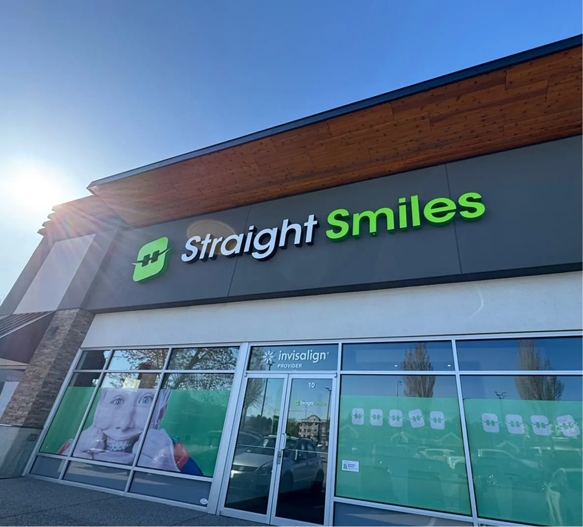 Straight Smiles orthodontic practice exterior with logo, featuring Invisalign provider sign and promotional image of a smiling patient.